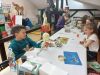 Zdjęcie pokazuje uczestnik&oacute;w/czki warsztat&oacute;w pracujących nad projektami